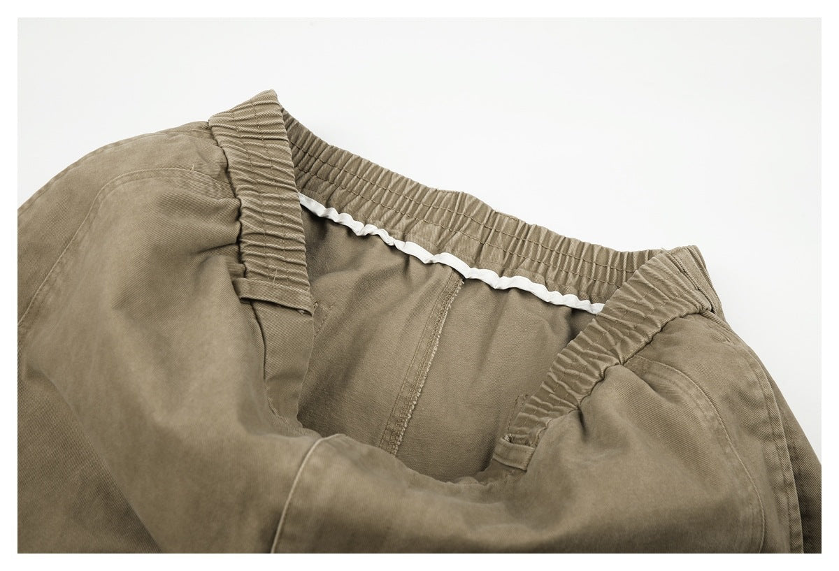 Interior close-up of taupe-brown trousers showing the elastic waistband and white drawstring.