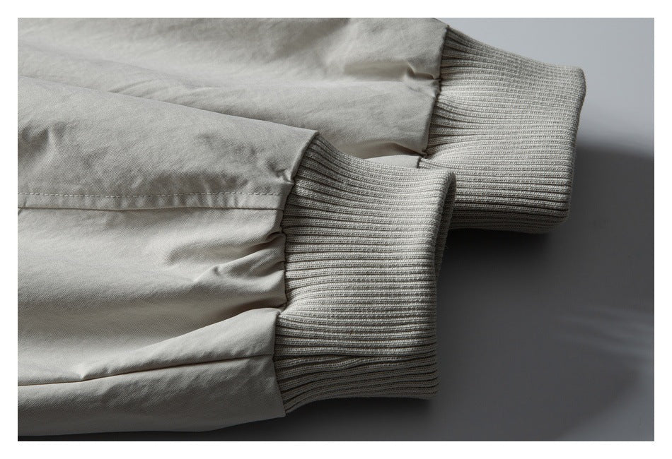 Close-up of two light gray jacket sleeves with wide ribbed knit cuffs.