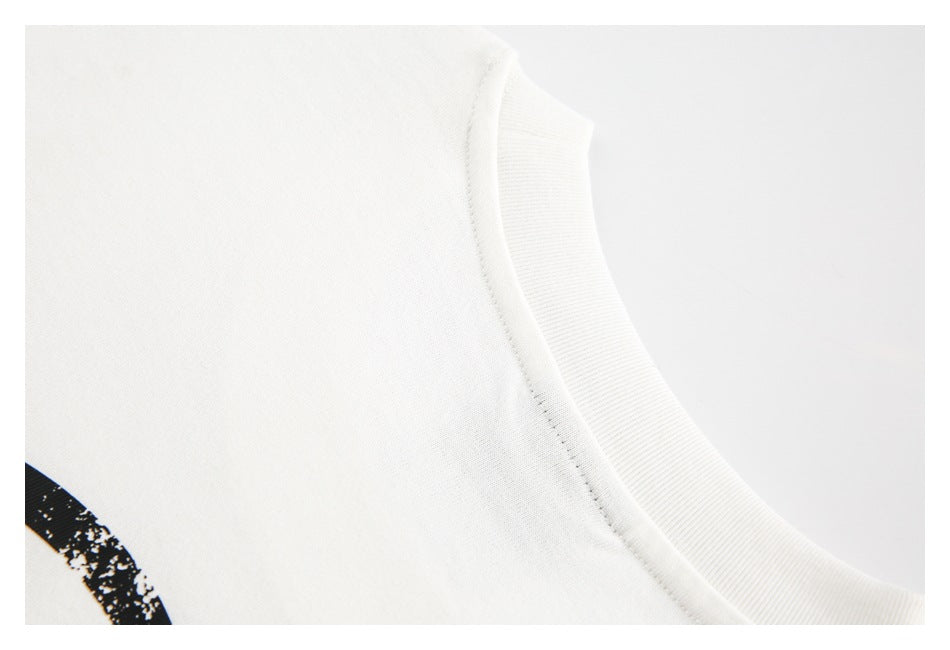 Close-up of a white ribbed crew neckline and seam, with part of a black print visible.