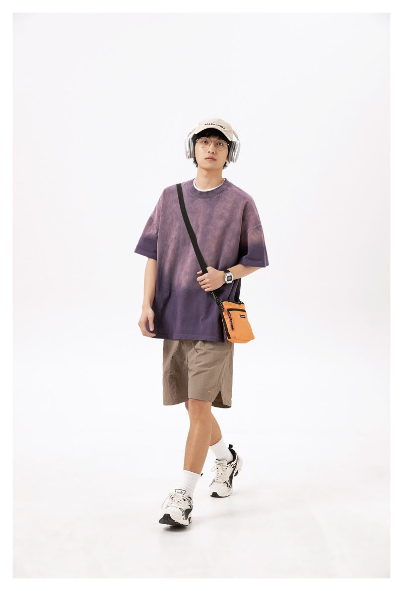 Model wearing taupe knee-length shorts beneath an oversized purple T-shirt.