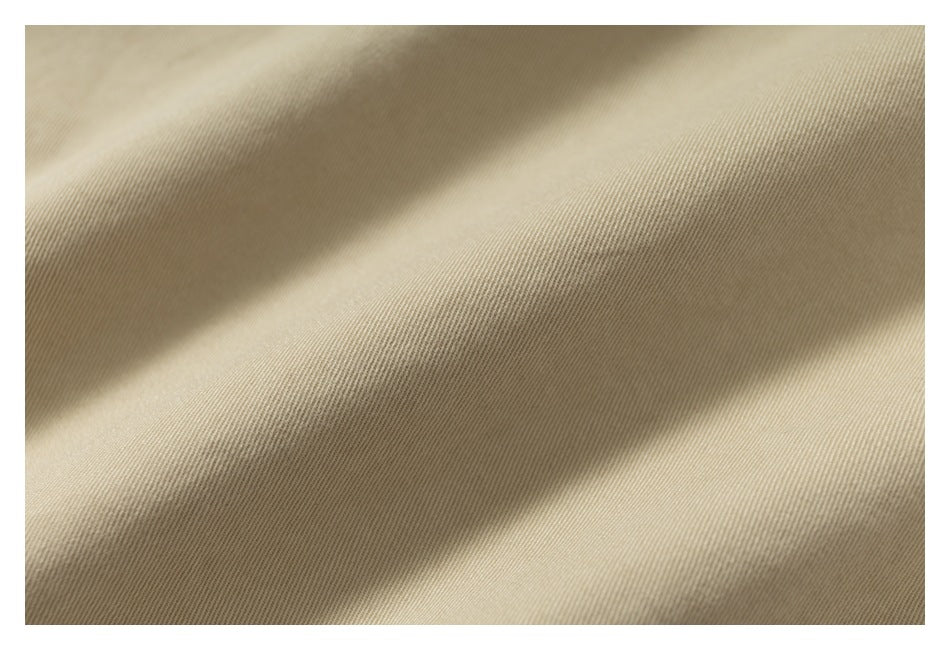 Close-up showing the fine diagonal weave and folds of tan fabric.