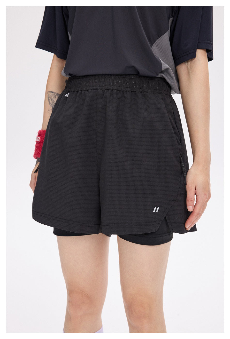 Front view of a model wearing black running shorts with an elastic waist, side pockets and built-in liner.
