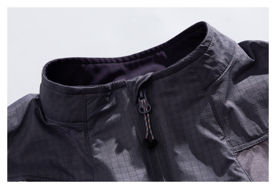 Close-up of a charcoal-gray grid-patterned jacket collar and front zipper with a corded pull.