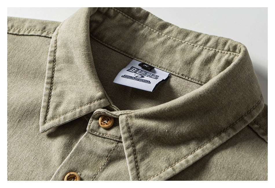 Close-up of an olive-gray garment collar, tan buttons, stitching, and a sewn-in neck label.