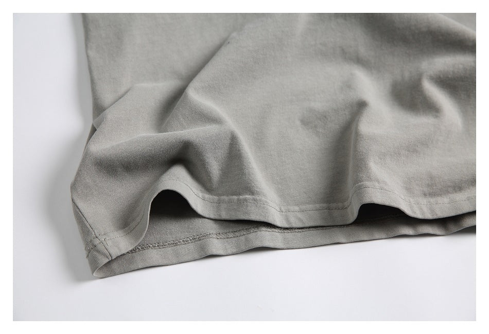 Close-up of the double-stitched hem on a light gray garment.
