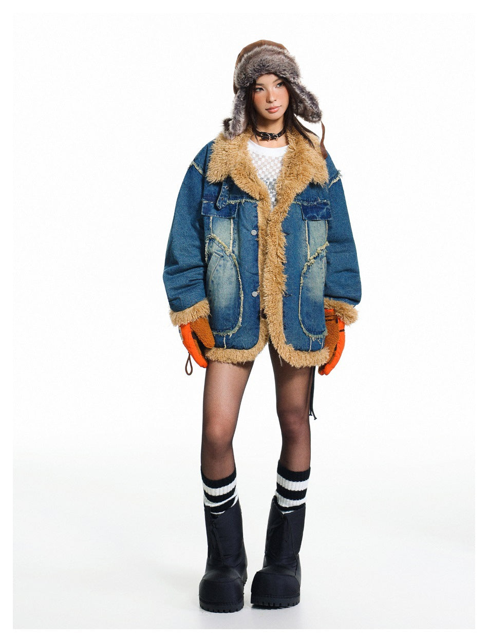 Full-length view of a model in an oversized blue denim jacket with tan pile trim, fur hat, orange gloves and black boots