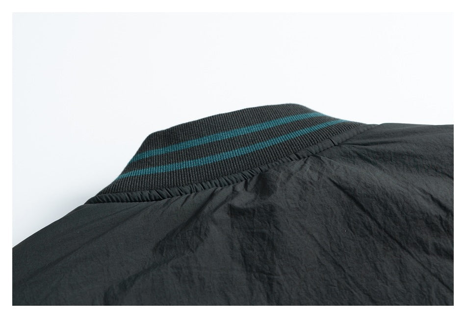 Close-up of a charcoal ribbed collar with two teal stripes.