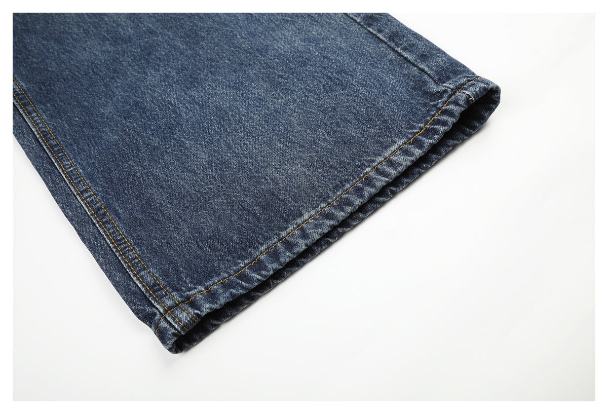 Close-up of a wide-leg dark blue jeans hem with contrast stitching.