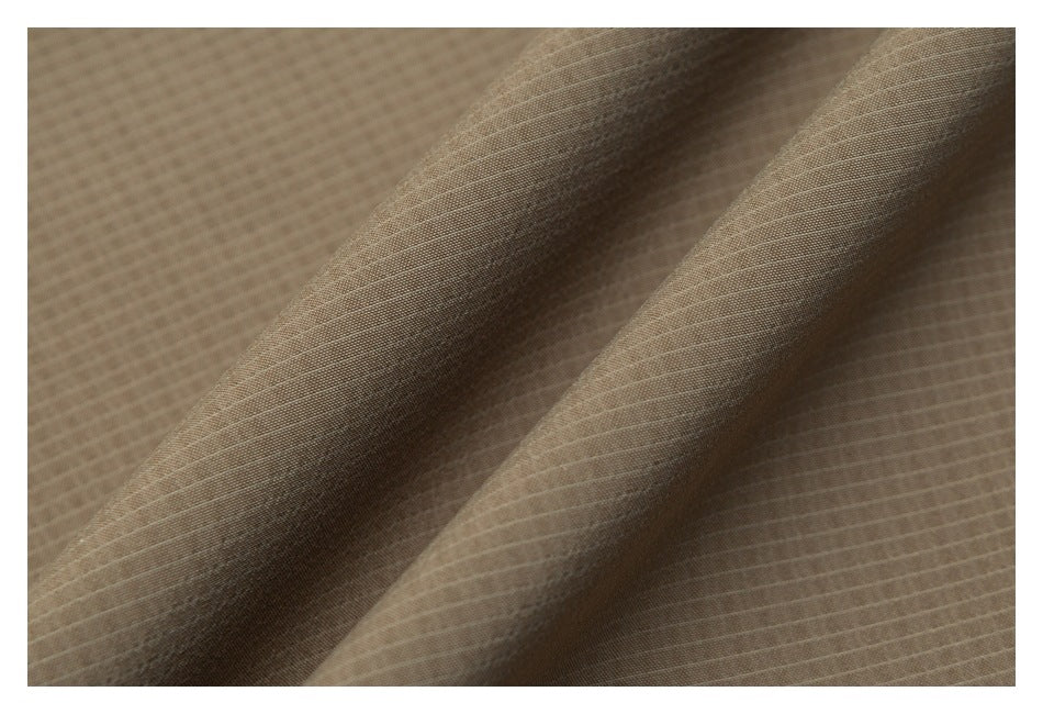 Close-up of taupe fabric with a fine, subtle grid texture and soft folds.