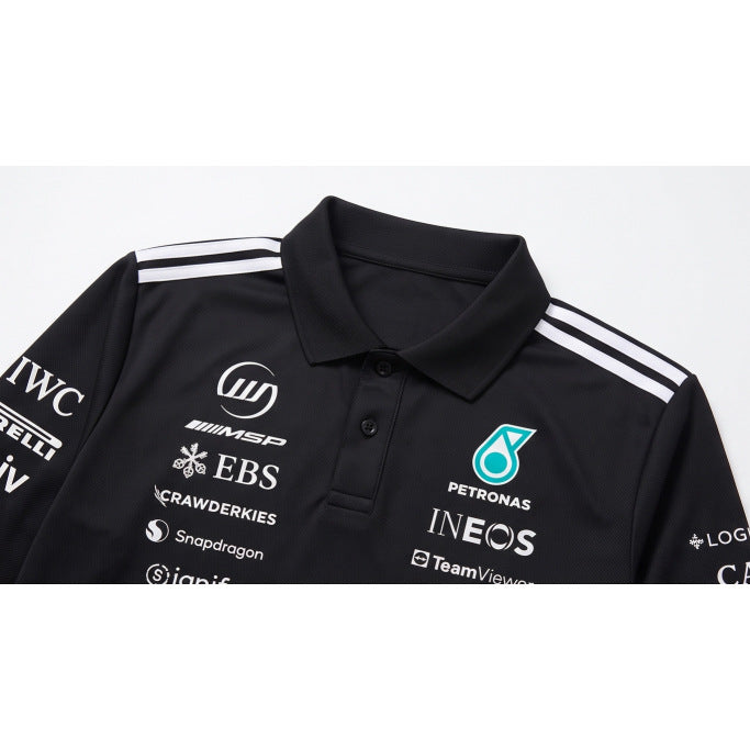 Close-up of a black collared polo with white shoulder stripes and printed motorsport sponsor logos.