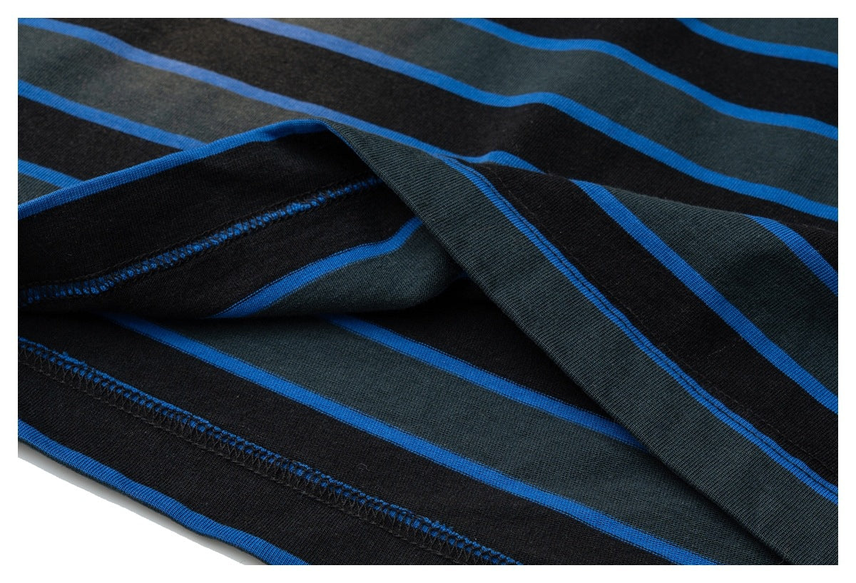 Close-up of the striped shirt fabric folded to reveal its stitched hem and underside.