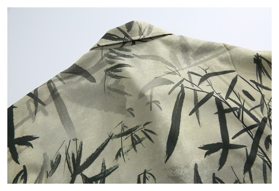 Close-up of the collar and upper shirt fabric, patterned with dark bamboo brushstrokes on beige.