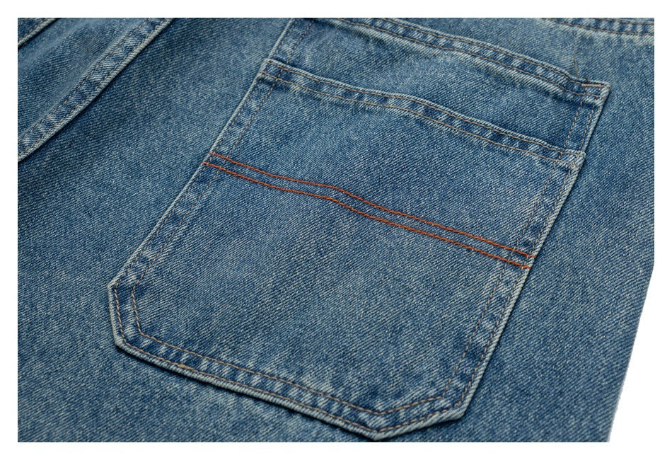 Close-up of a blue denim back pocket with double rows of orange-brown stitching.
