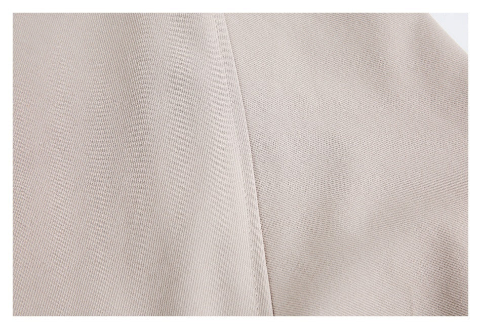 Extreme close-up of beige garment fabric and a vertical seam.