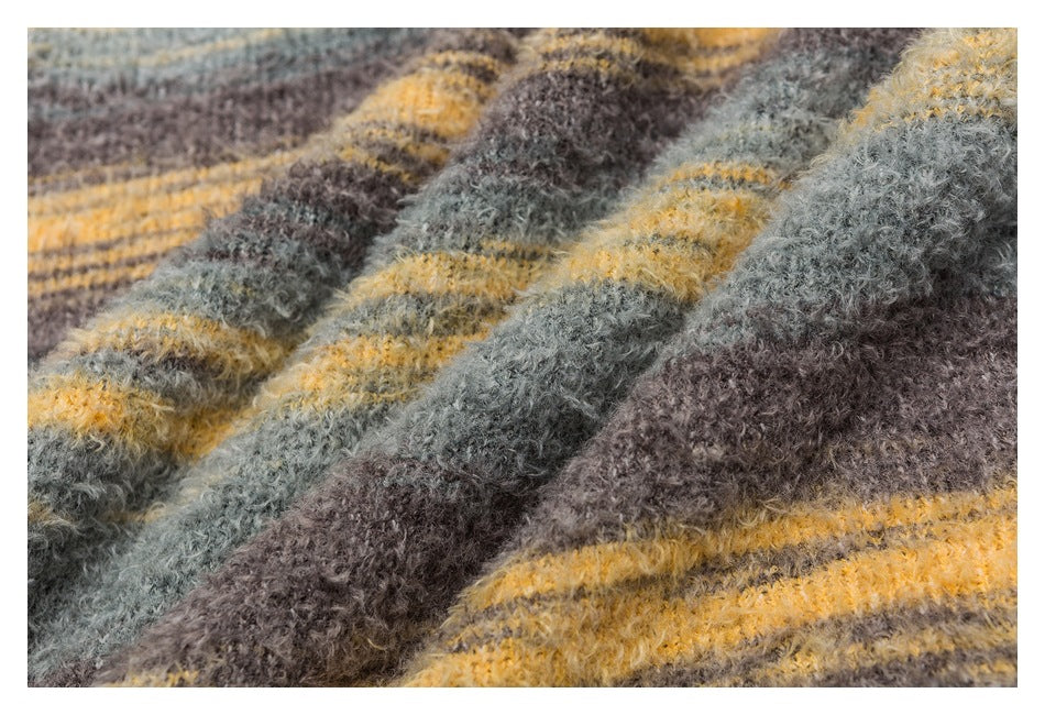 Close-up of fuzzy knit fabric with irregular gray, brown, and mustard-yellow stripes.