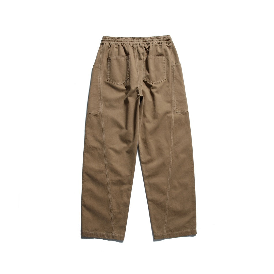 Back view of brown pants with an elastic waistband, two rear pockets, and large side utility pockets.
