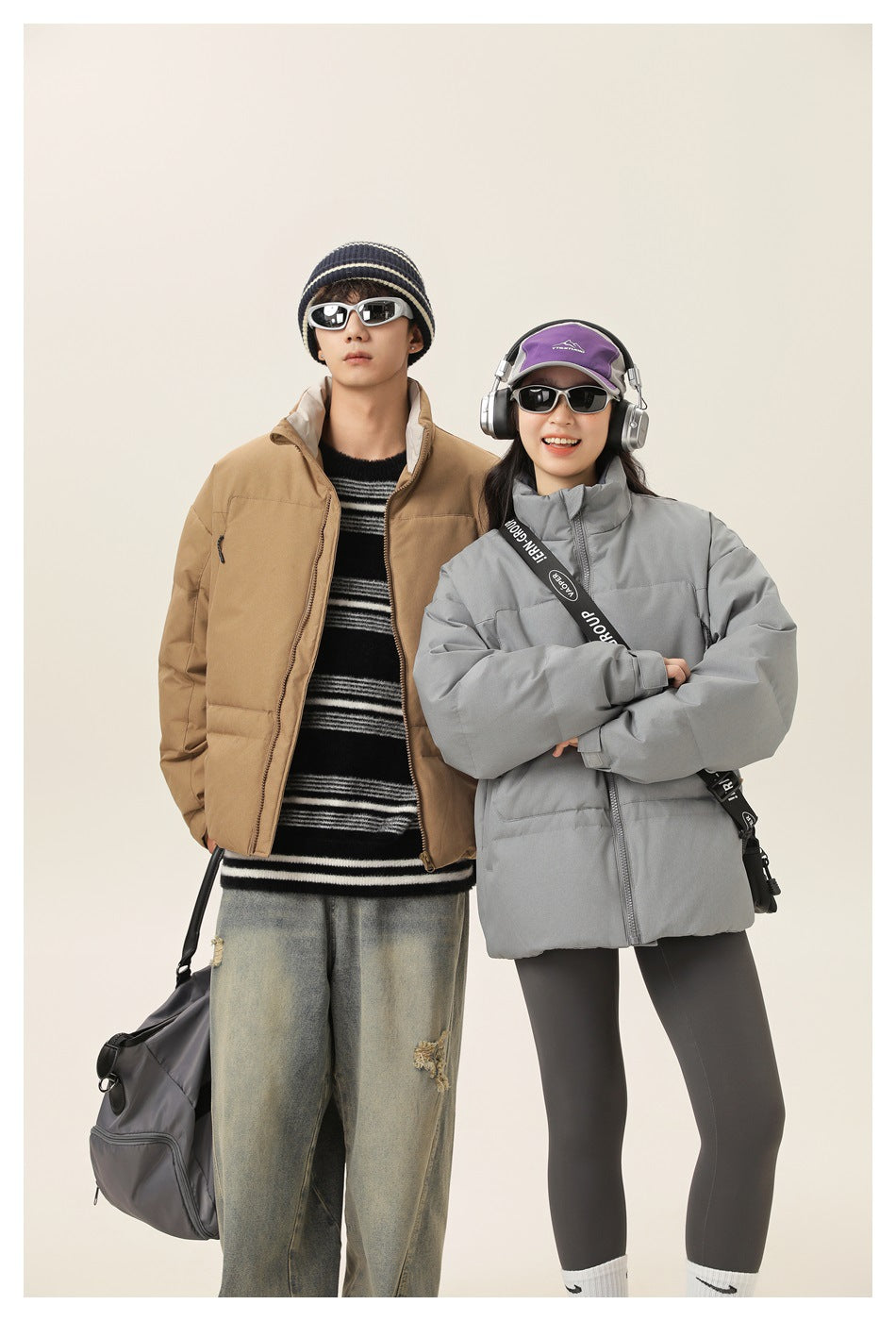 Two models wearing tan and gray padded jackets with high collars and front zippers.