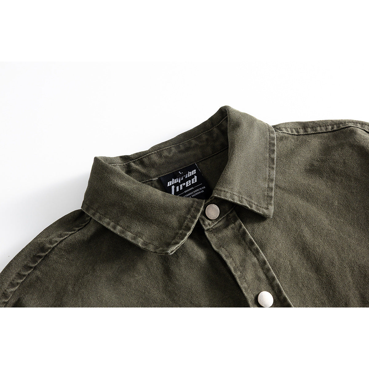 Close-up of an olive-gray shirt collar with a metal snap and a small black neck label.