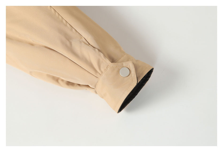 Close-up of the tan jacket sleeve cuff with a snap tab and black lining visible.