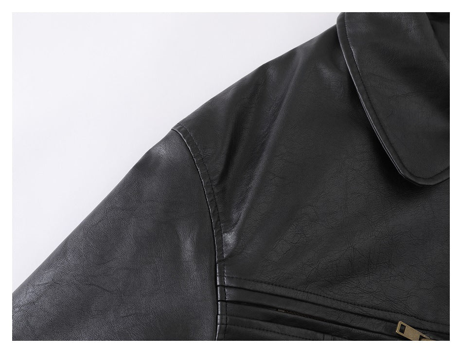 Close-up of a black jacket's shoulder seam, sleeve, collar edge, and front stitching.