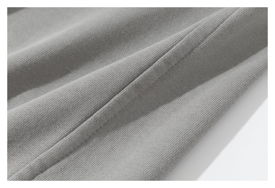 Close-up of gray fabric folds showing a raised seam and knit texture.