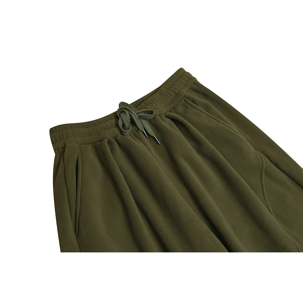 Close-up front view of olive-green fleece pants with an elastic drawstring waist and angled side pockets.