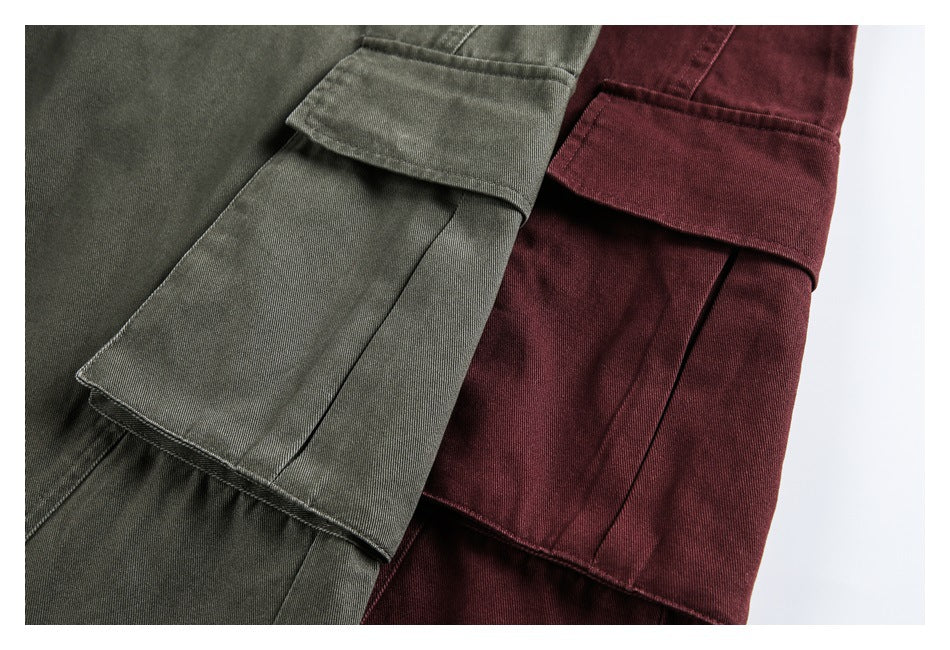 Close-up of flap cargo pockets on olive and burgundy pants.