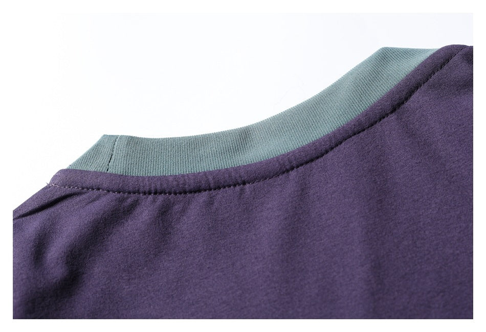 Close-up of a purple garment neckline with a contrasting teal ribbed collar.