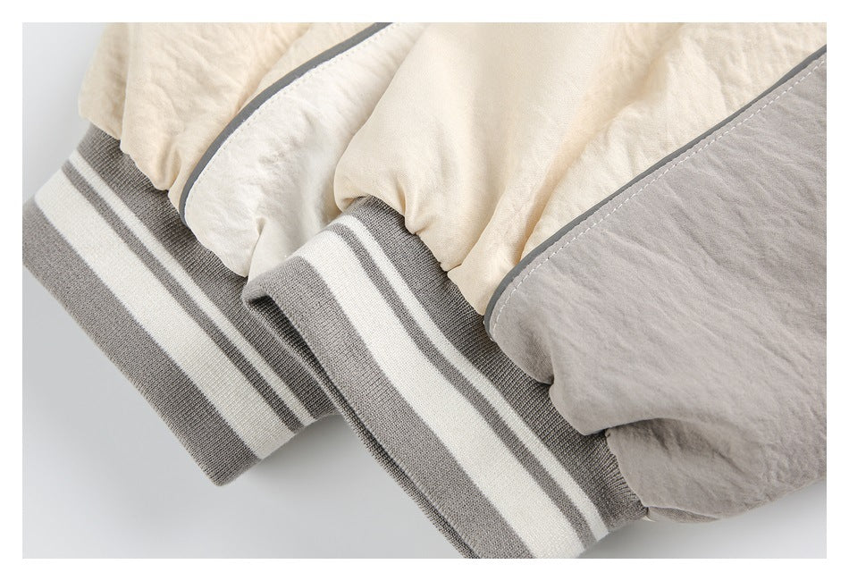 Close-up of cream jacket sleeves and gray-and-cream striped ribbed cuffs.