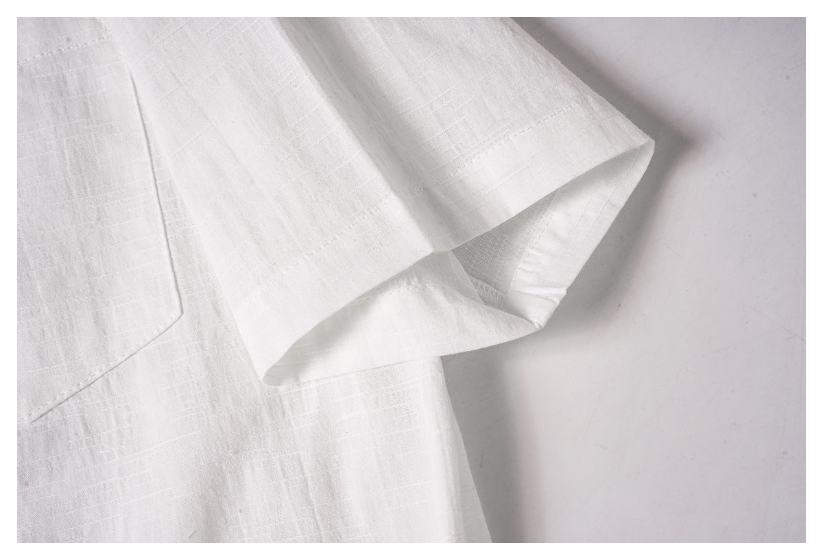 Close-up of the white shirt's short sleeve opening and stitched edge.