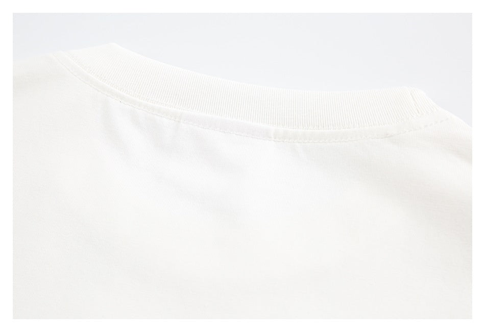 Close-up of a white crew neckline with ribbed trim and visible stitching.