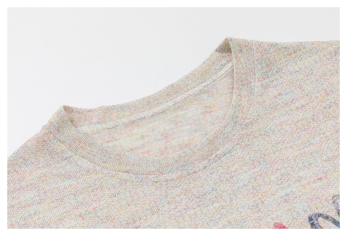 Angled close-up of the top's crew neckline and multicolor-flecked fabric.
