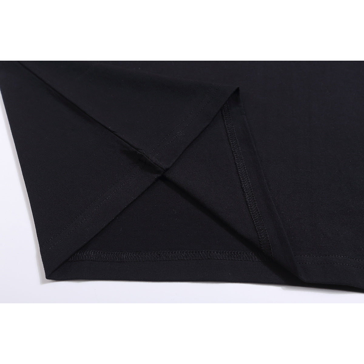 Close-up of a black T-shirt’s sleeve and hem stitching.