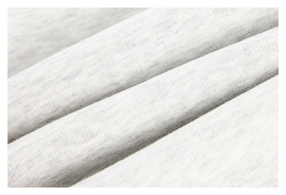 Macro view of light heather gray knit fabric arranged in soft diagonal folds.