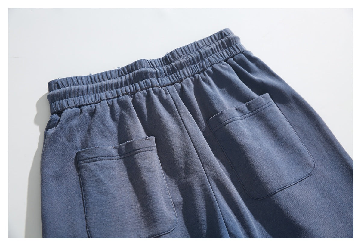 Back view of navy pants laid flat, with an elastic waistband and two large patch pockets.