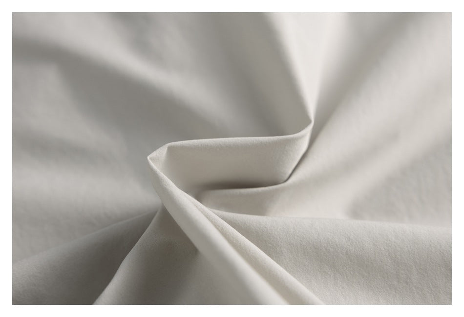 Close-up of softly folded beige fabric showing its surface and drape.