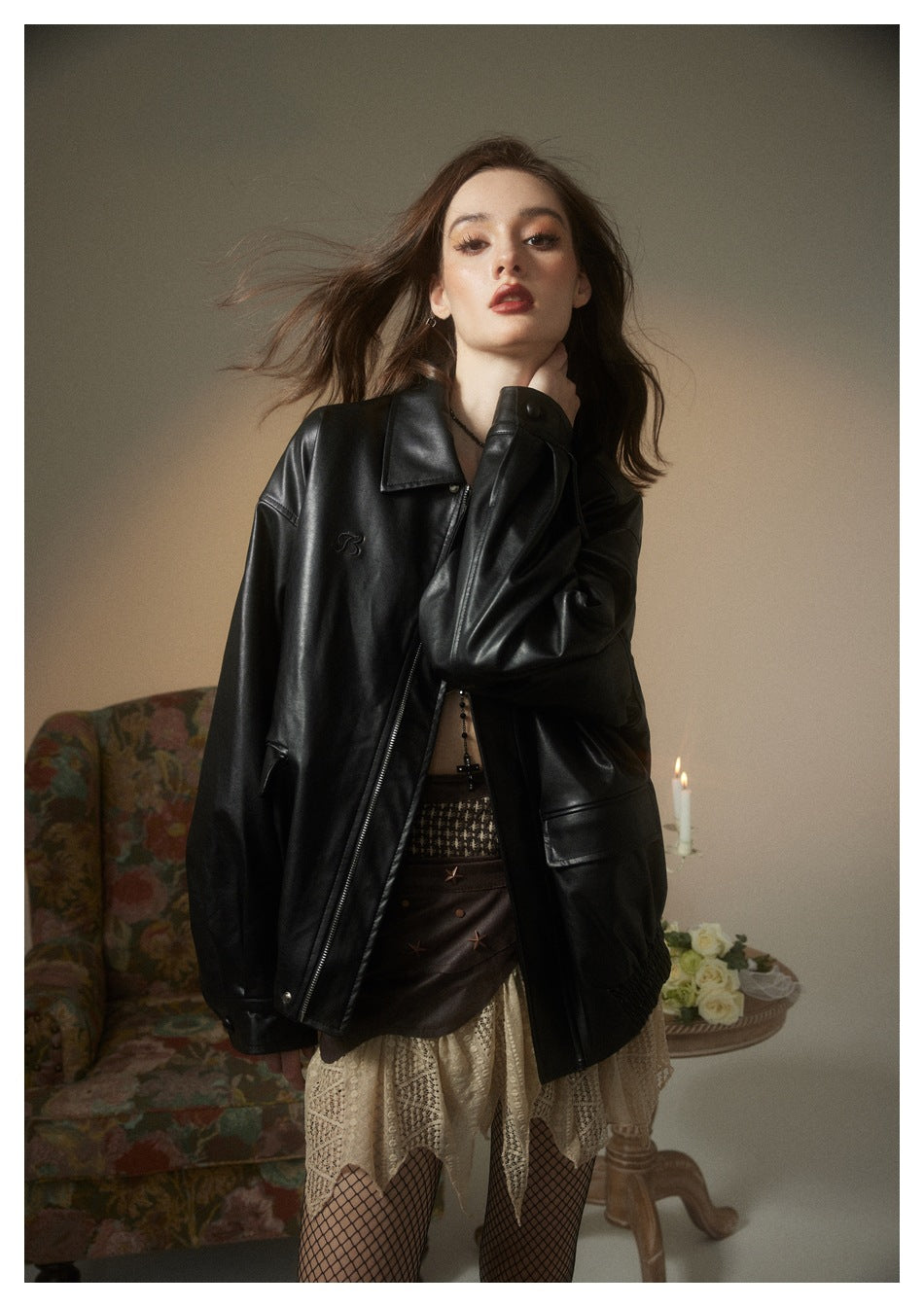 Model wearing an oversized glossy black zip-front jacket with a pointed collar and flap pockets.