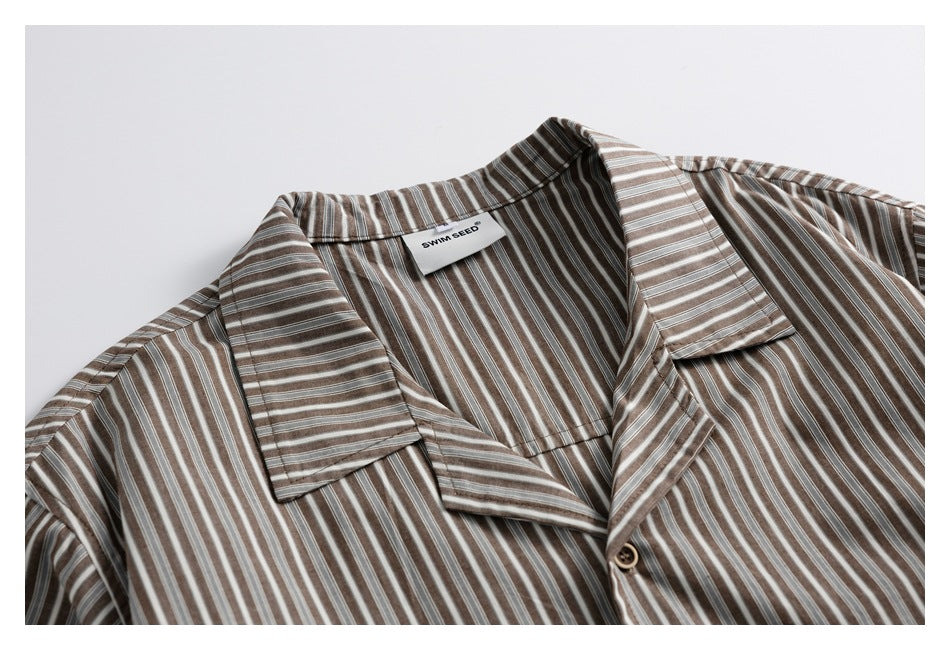 Close-up of the brown, gray and white striped shirt's camp collar, button and sewn-in neck label.