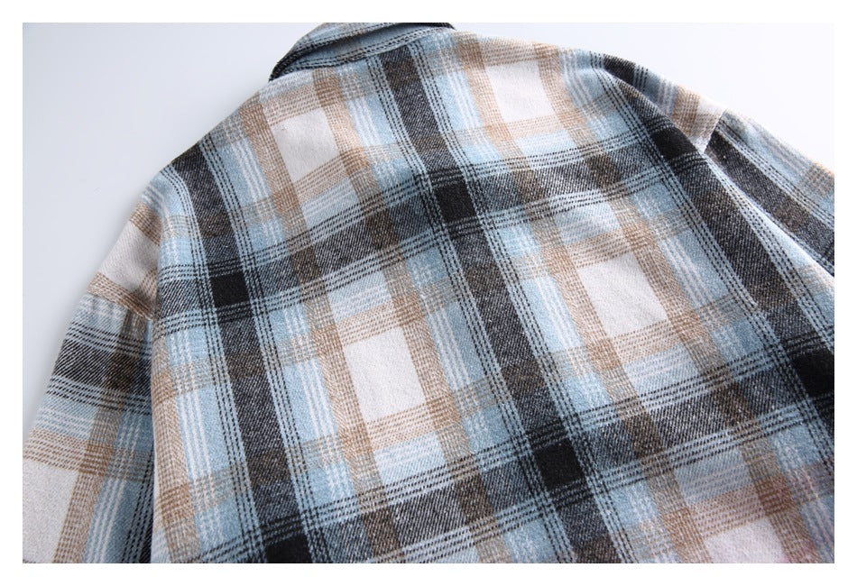 Close-up of the back and shoulder of a blue, tan, and dark plaid shirt.