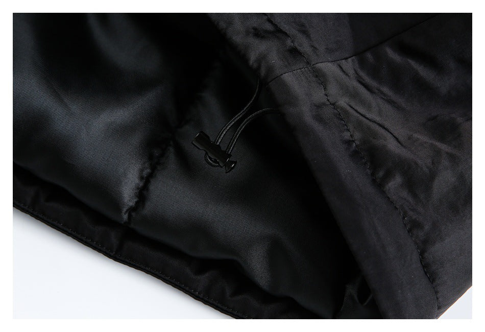 Close-up of a black garment interior showing a small adjustable drawcord and stitched seams.