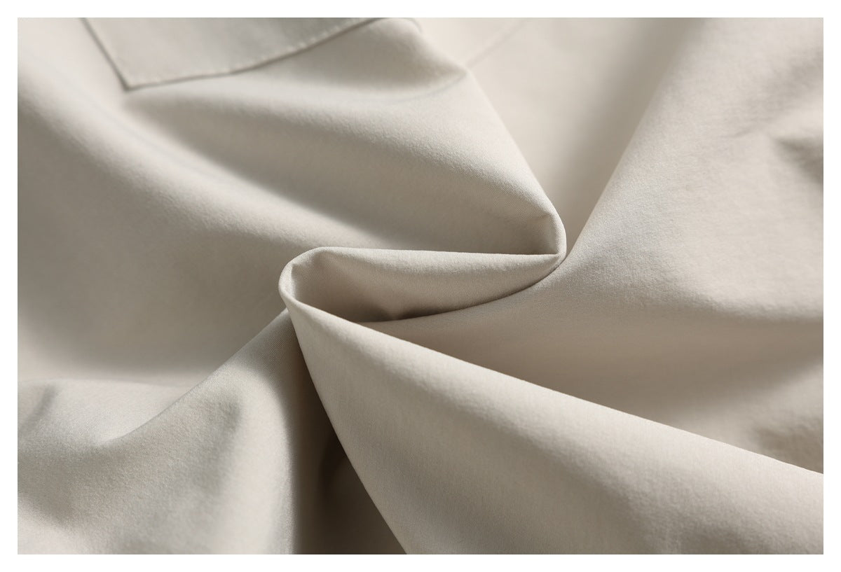Close-up of smooth light beige fabric draped into soft folds.