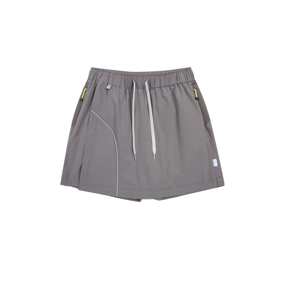 Dark gray skort flat lay with drawstring waist, curved light piping and yellow zipper pulls on side pockets