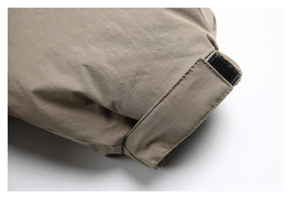 Close-up of the taupe jacket sleeve cuff with an adjustable hook-and-loop tab.