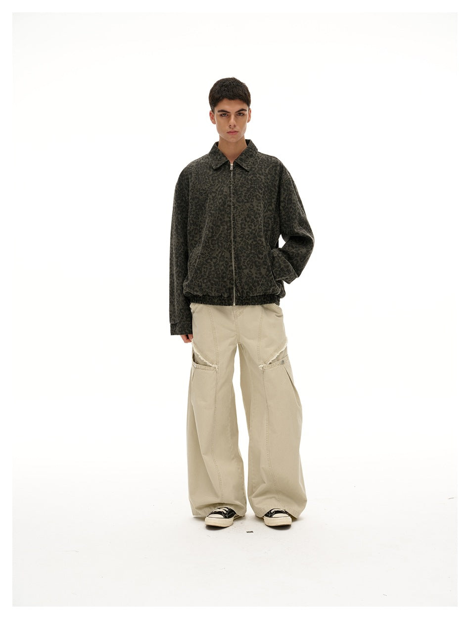 Front view of a model wearing a dark gray leopard-print zip jacket and loose beige pants.