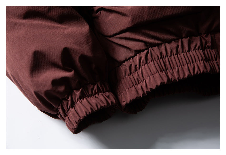Close-up of gathered elastic edging along the burgundy jacket hem or cuffs.