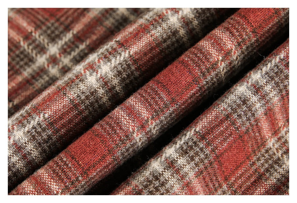 Close-up of folded red, cream, and brown plaid fabric with a textured weave.