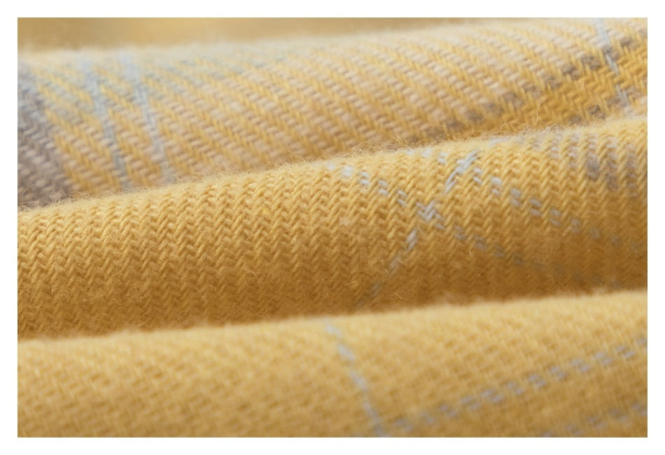 Macro view of the textured weave in mustard yellow plaid fabric.