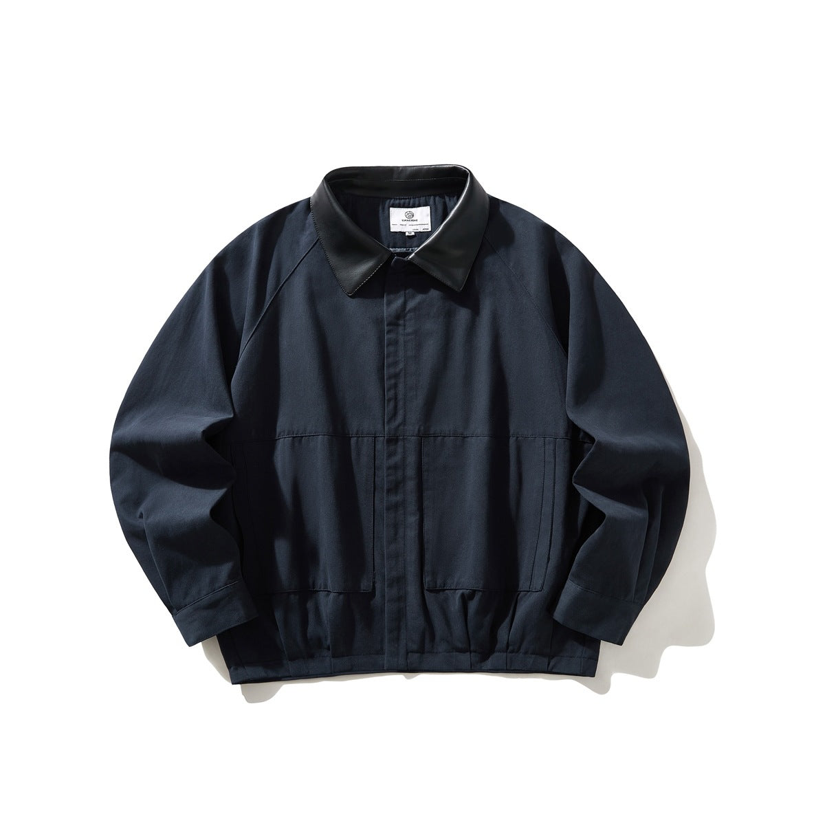 Navy jacket with black leather-look collar, raglan sleeves, front pockets and gathered hem, flat lay
