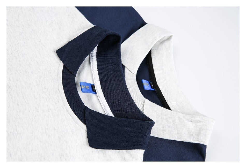 Close-up of overlapping gray and navy polo collars with blue neck labels.