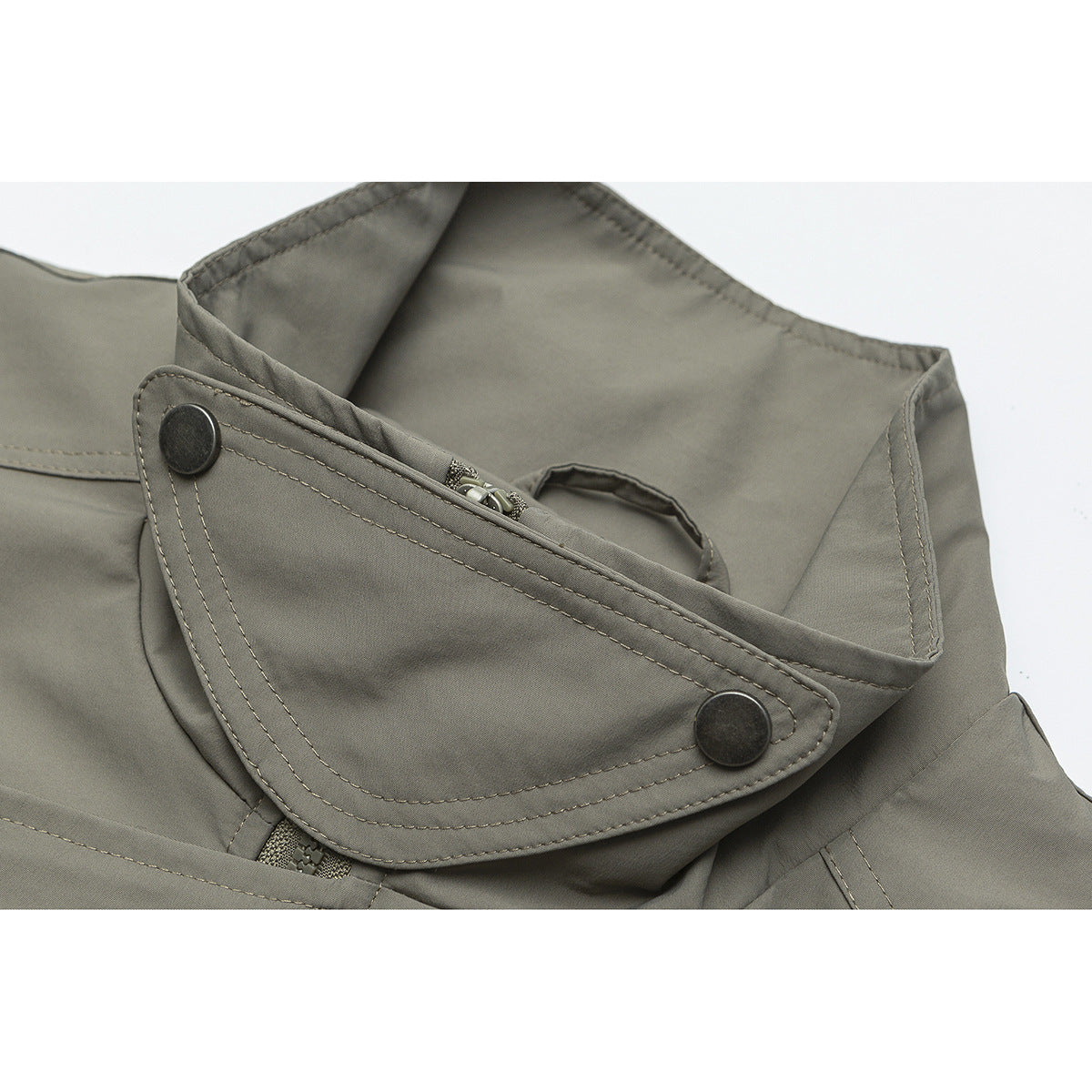 Close-up of an olive-gray jacket collar with a snap-button tab and partially visible zipper.